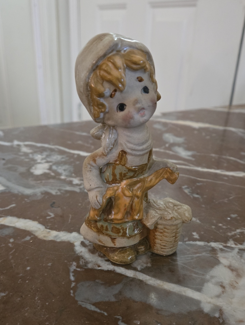 Vintage Hand-made and Painted Porcelain Statue Of A Girl Folding Clothes